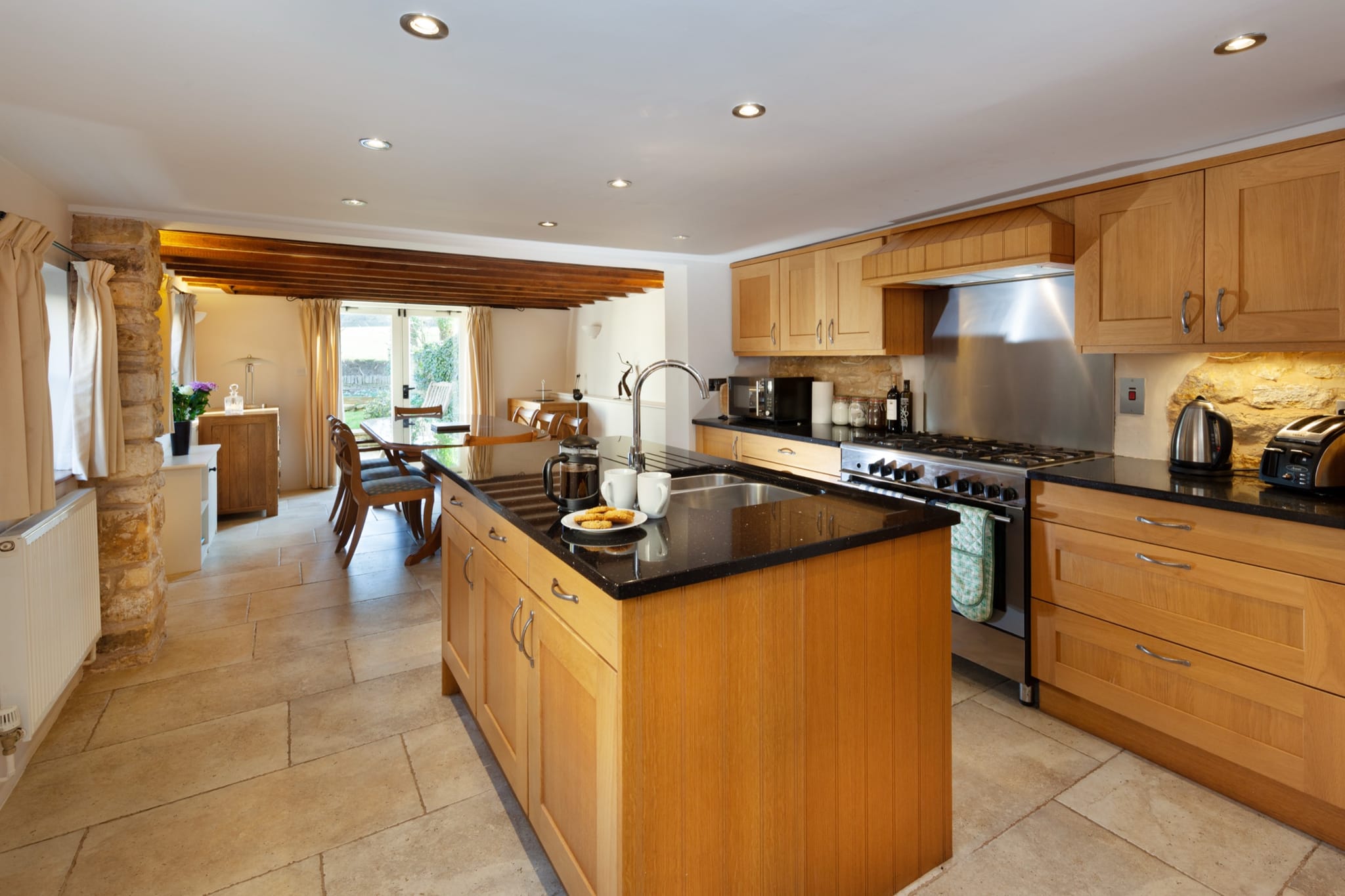 Open-plan kitchen with a central island, range cooker and oak cabinetry
